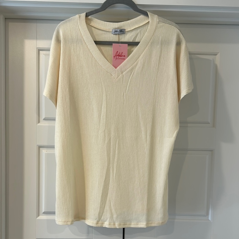 Cream V-Neck shirt with short sleeves.